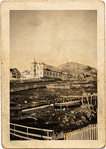 Old church with fishing boats and rocky hills